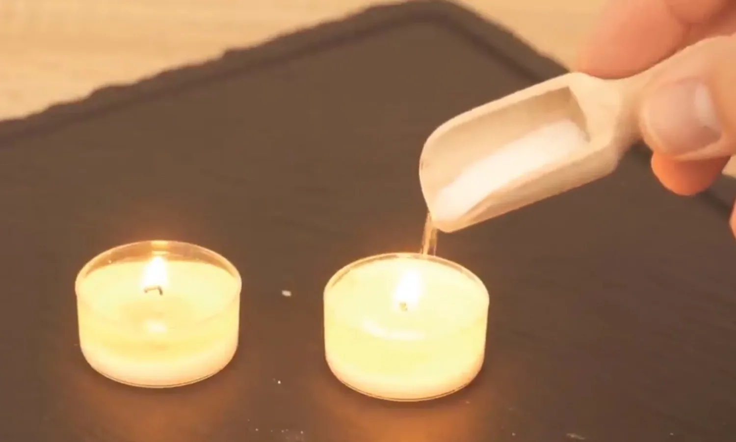 ZIEN: Hij strooit een beetje zout in een waxinelichtje. Kijk naar wat er dan gebeurt!
