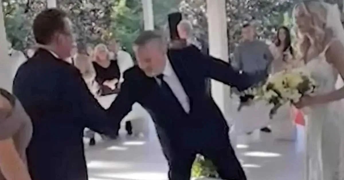 Vader loopt met z’n dochter het gangpad af en stopt naast haar stiefvader. Wat hij dan doet, breekt je hart!