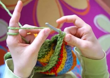 Onbekende maakt een gehaakt mutsje voor een meisje tijdens haar eerste vlucht