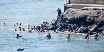 Bizarre beelden: Duizenden migranten overspoelen Spaanse exclave vanuit Marokko